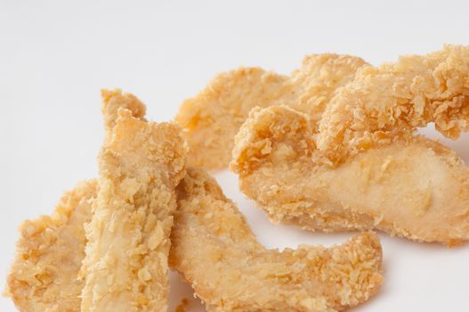 chicken pieces in bread crumbs close up on a white background