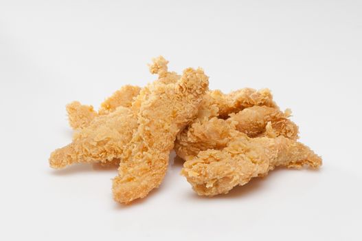 chicken pieces in bread crumbs close up on a white background