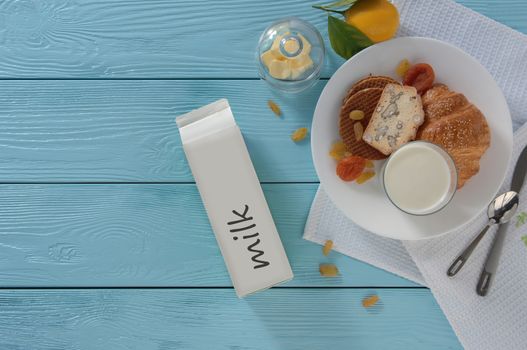 milk in carton box and baking on blue wooden background, top view. healthy eating concept