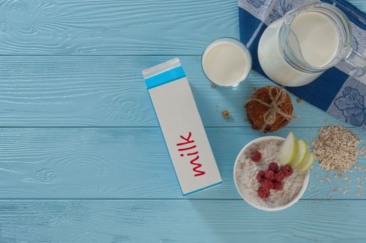 milk in a cardboard box and cookies on a blue wooden background, top view. healthy eating concept