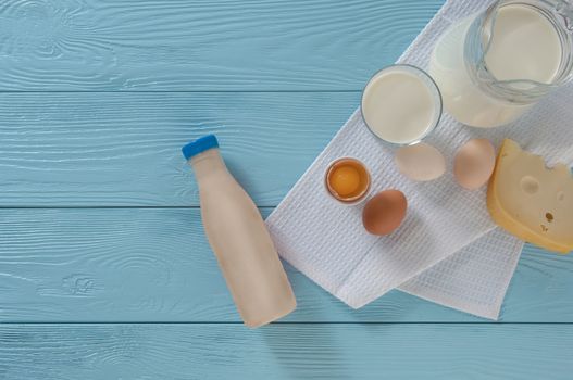 dairy products with cheese and eggs on a blue wooden background, top view. healthy eating concept