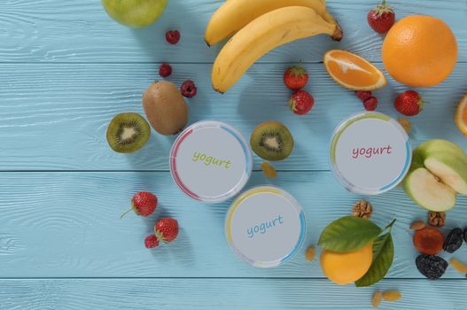 yogurt in a container with tropical fruits on a wooden background, top view. healthy eating concept