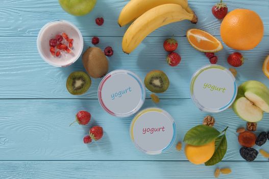 yogurt in a container with tropical fruits on a wooden background, top view. healthy eating concept