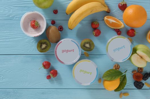 yogurt in a container with tropical fruits on a wooden background, top view. healthy eating concept