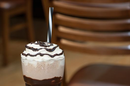 cold milk chocolate cocktail in a glass with a straw