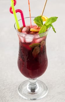 red fruit drink in glass with mint and lemon