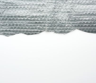 fragment of a transparent film with air for transportation of parcels is glued on gray polyethylene, inside of the envelope