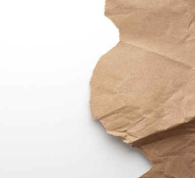 fragment of crumpled blank sheet of brown wrapping kraft paper with torn edges, vintage texture for the designer, white background