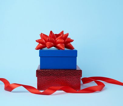 stack of wrapped gifts with knotted bows on a blue background, festive backdrop