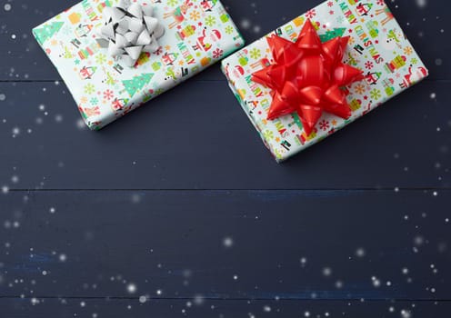 gift wrapped in multi-colored paper on a blue wooden background, festive backdrop, top view, copy space