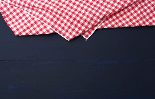 white red checkered kitchen towel on a blue wooden background, picnic background, copy space