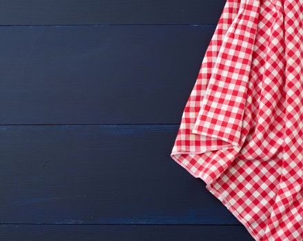 white red checkered kitchen towel on a blue wooden background, picnic background, copy space
