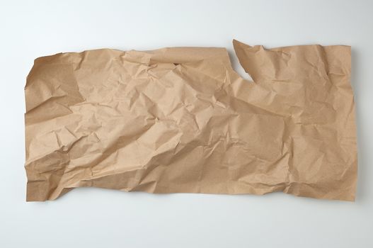 crumpled brown sheet of paper for packaging goods on white background, close up