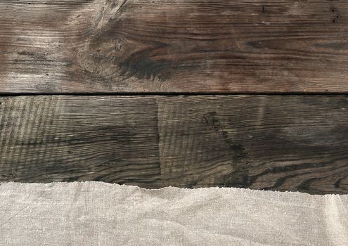 gray kitchen textile towel folded on a gray wooden table from old boards, top view, empty space. Rustic texture. Retro background