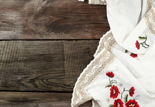 white kitchen textile towel folded on a gray wooden table from old boards, top view, empty space. Rustic texture. Retro background