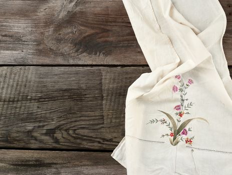 white kitchen textile towel folded on a gray wooden table from old boards, top view, empty space. Rustic texture. Retro background