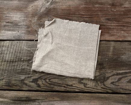 gary kitchen textile towel folded on a gray wooden table from old boards, top view, empty space. Rustic texture. Retro background