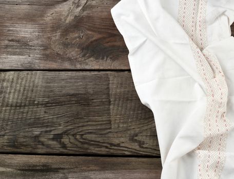 white kitchen textile towel folded on a gray wooden table from old boards, top view, empty space. Rustic texture. Retro background
