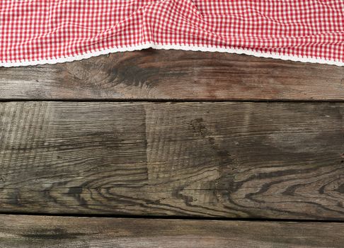 red-white textile kitchen towel on a wooden background from old gray boards, place for an inscription