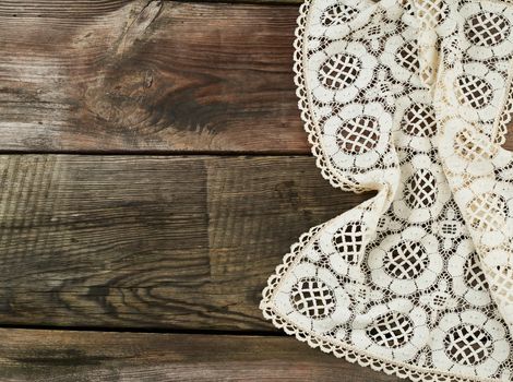 white kitchen textile lace towel folded on a gray wooden table from old boards, top view, empty space