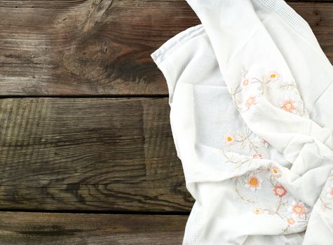white kitchen textile towel folded on a gray wooden table from old boards, top view, empty space. Rustic texture. Retro background