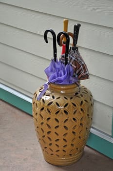 Decorative ceramic umbrella stand filled with colorful umbrellas