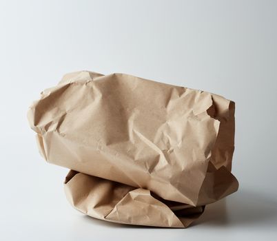 pile of twisted brown sheets of paper on a white background, craft paper for packaging