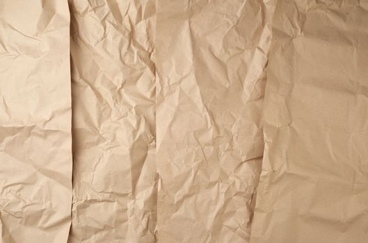 crumpled paper texture from brown sheets kraft packaging paper, abstract backdrop for designers, full frame