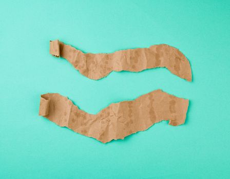 brown piece of paper with bold spots and a swirling corner on a green background, copy space