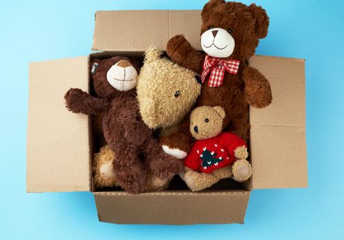brown cardboard box with various teddy bears, top view, concept of assistance and volunteering