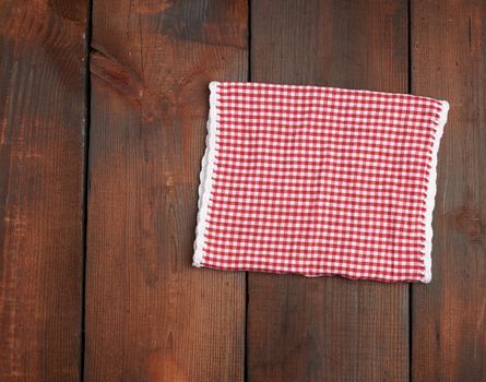 white red checkered kitchen towel on a brown wooden background, picnic background, copy space