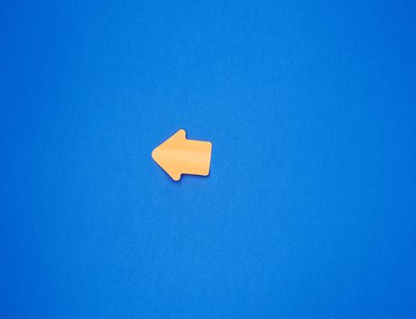 orange paper sticker in the form of an arrow pointer is glued on a blue background, place for an inscription