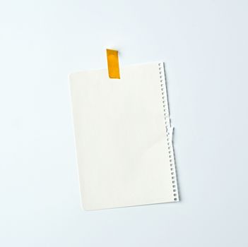 white crumpled sheet of paper torn from a spiral notebook and glued with yellow electrical tape on a white background, place for text. Design space