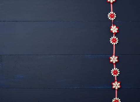 white red felt snowflakes on a blue wooden surface, empty space