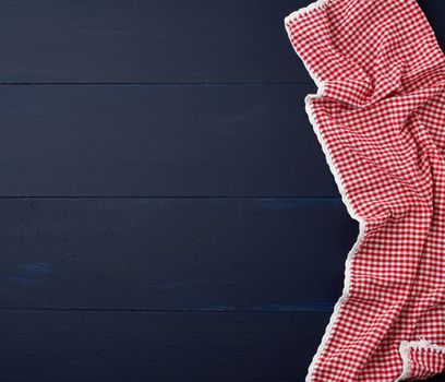 white red checkered kitchen towel on a blue wooden background, picnic background, copy space