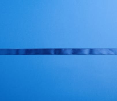 dark blue silk ribbon on a blue background, festive backdrop, place for text