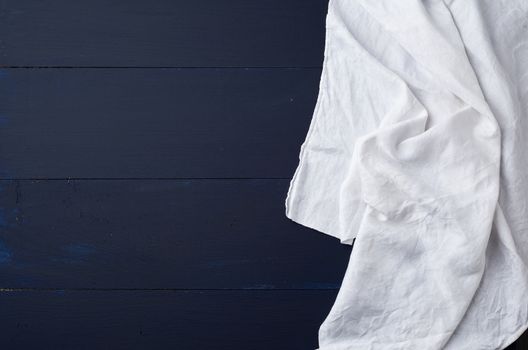 white linen towel on blue wooden background, top view, copy space