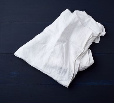white linen towel on blue wooden background, top view, copy space