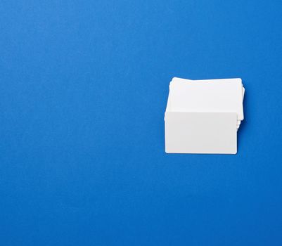 stack of rectangular white blank business cards on a blue background. Corporate business concept