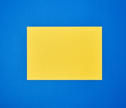 blank yellow sheet of A4 paper on a blue background. Business template. Copy space