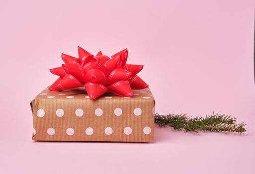 stack of kraft paper wrapped gifts, spruce branch. Christmas greeting concept.