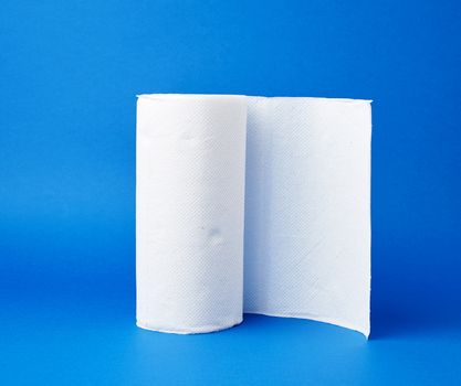 twisted roll of white paper towel on a blue background. Paper sheet. Household equipment. White napkin.