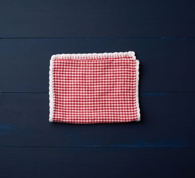 white red checkered kitchen towel on a blue wooden background, picnic background, copy space