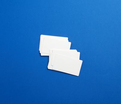 stack of rectangular white blank business cards on a blue background. Corporate business concept