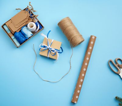 square gift box, rope and prize wrapping paper. Flat packaging. Festive christmas background.