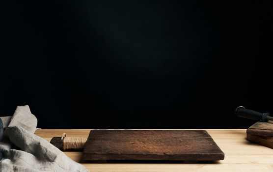 very old empty wooden rectangular cutting board, black background 