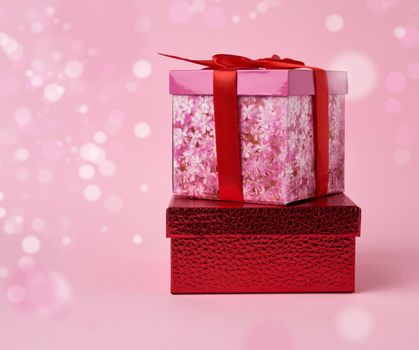 stack of wrapped gifts on a pink background with bokeh. Beautiful box gift, great design for any purposes