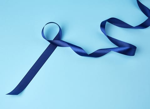 blue silk thin ribbon twisted on a blue background, trendy classic color, close up