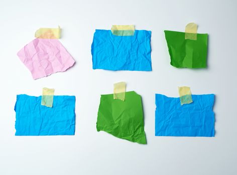 empty multi-colored crumpled pieces of paper are glued with duct tape on a white background