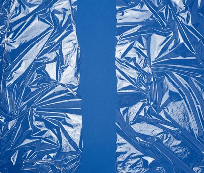 texture of a transparent stretching plastic film for packaging products on a blue background, full frame, close up